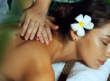 A woman enjoying a spa treatment with a flower in her hair.