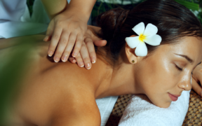 A woman enjoying a spa treatment with a flower in her hair.