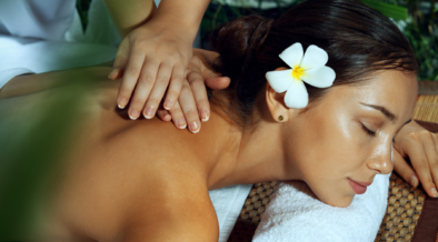 A woman enjoying a spa treatment with a flower in her hair.