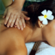 A woman enjoying a spa treatment with a flower in her hair.