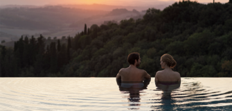 A couple in an infinity pool at RAKxa resort at Catelfalfi in Tuscany.