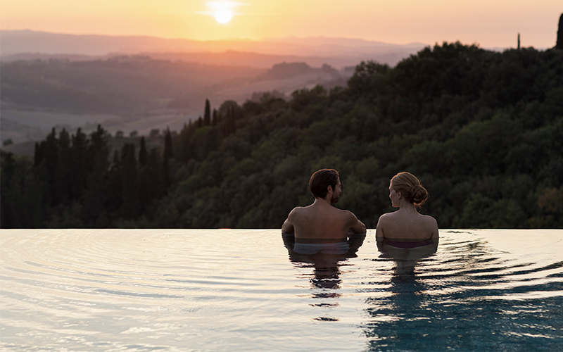 A couple in an infinity pool at RAKxa resort at Catelfalfi in Tuscany.