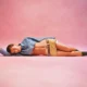 Gen Z Miu Miu fashion woman laying down with pink background