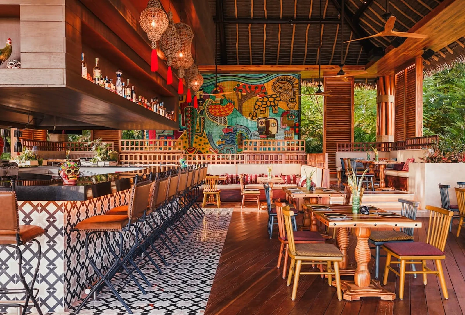 Open-air restaurant and lounge inside BON Luxury Theme Park, with bar seating, dining tables and colorful Mexican-inspired artwork.