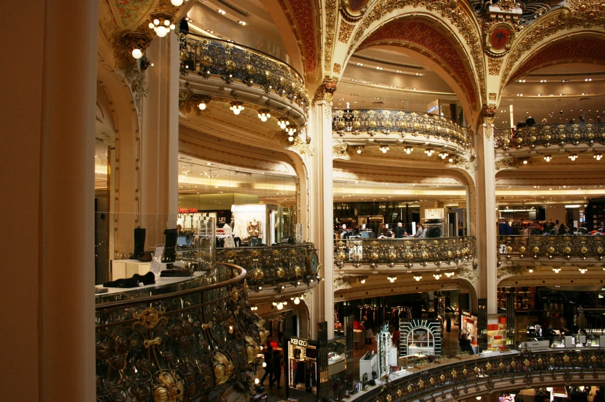 Interior of Galeries Lafayette in Paris, with ornate balconies and multiple retail floors beneath the glass dome.