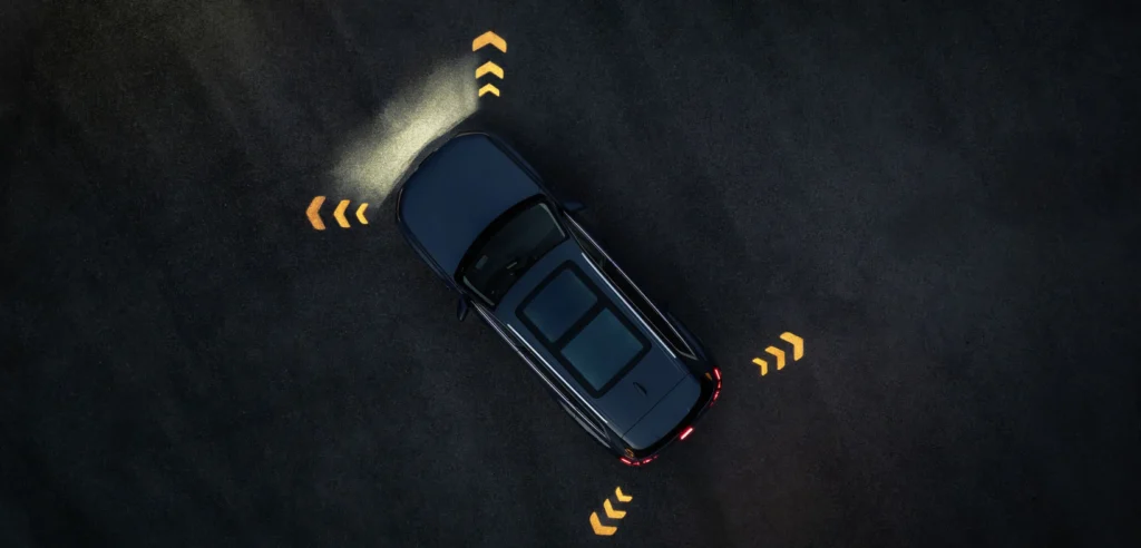 Blue Audi Q7 SUV seen from above on a dark surface with illuminated directional arrows around the vehicle.
