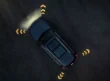 Blue Audi Q7 SUV seen from above on a dark surface with illuminated directional arrows around the vehicle.