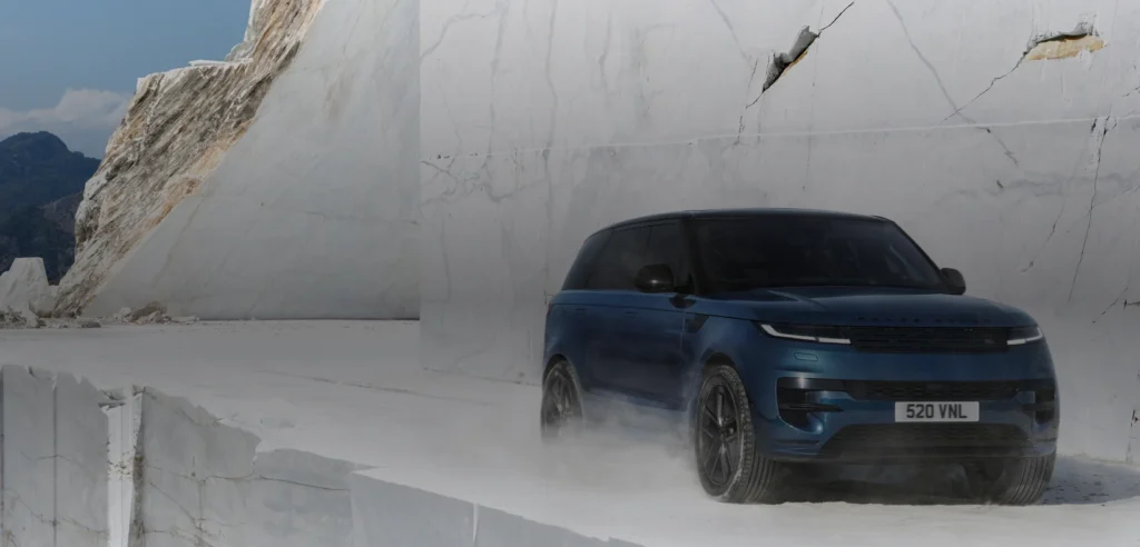 Blue Range Rover Sport Electric driving through a white Carrara marble quarry.