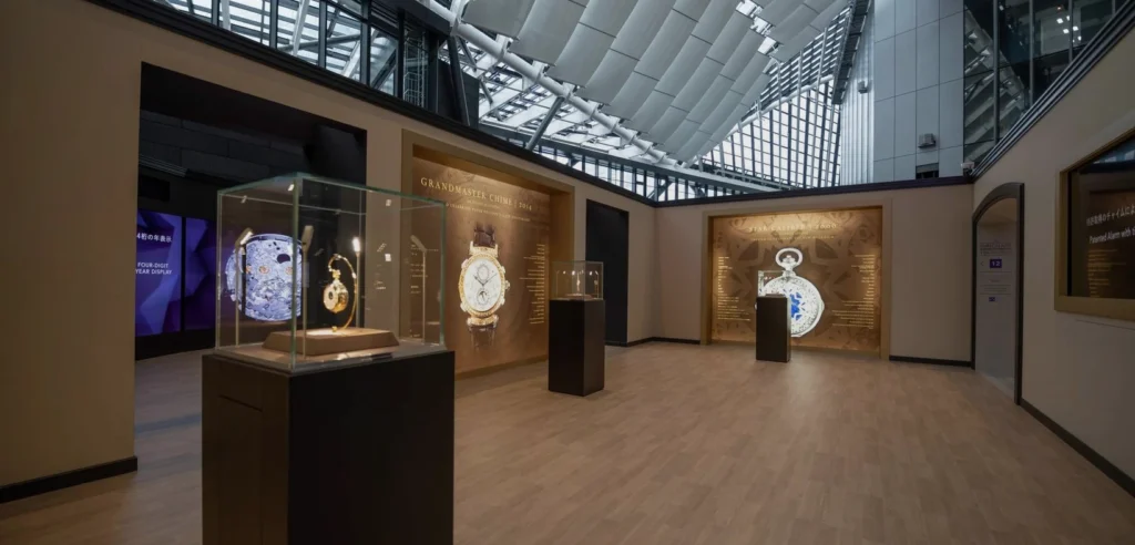 Patek Philippe Watch Art Milan 2026 exhibition gallery with vitrines and illuminated historic-watch displays.
