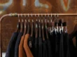 Dark and brown garments hanging in a boutique, representing clothing inventory generally.