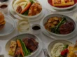 A selection of Delta One's newly announced main courses, including plated meals, bread, a burger and drinks.