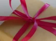 Ribbon-tied gift boxes arranged with evergreen sprigs on a tabletop.